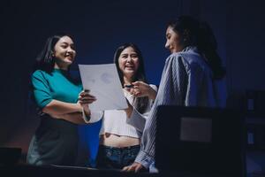 Three women standing in front of a computer screen photo