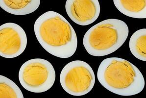 Sliced boiled chicken eggs on a dark background photo