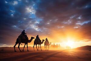 A group of people riding camels in the desert at sunset photo