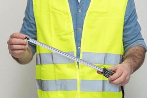 Accurate measurements in successful implementation of a construction project. builder uses a tape measure to measure and mark out. concept of accurate measurements in professional construction photo