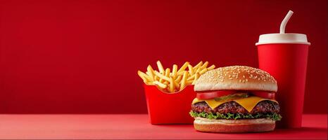Beef burger, french fries and cola, close-up shot, red background with copy space photo