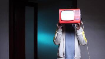 a man has a TV instead of a head. Man holding portable television in front of face video