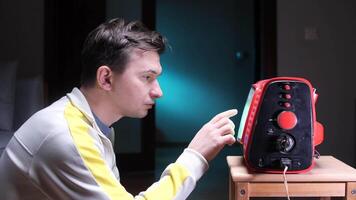 Man staring at old tube TV screen with static and reaching out to screen video