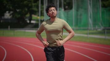 A Young Man Running on a Track Field Under the Bright Sunlight and Warm Conditions video