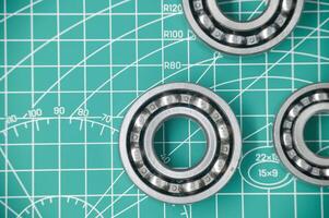 Close-Up of Ball Bearings on a Gridded Measurement Mat Surface photo