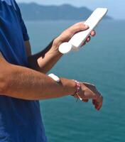Using sunscreen cream on the arm against sea under sunlight photo