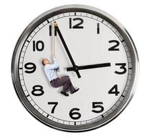 A man hanging from a clock with a rope photo