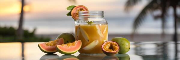 Tropical guava and passion fruit juice in glass jar with sunset beach and palm trees photo