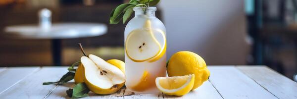 Pear and lemon cooler in frosted bottle on white wooden surface photo