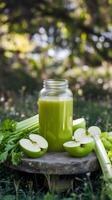 Green apple and celery juice in a rustic forest setting photo