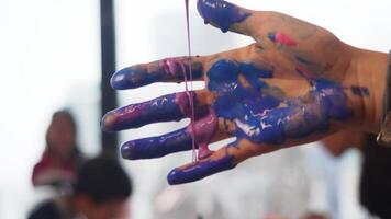 artiste les usages inhabituel technique de La peinture avec le sien mains. épais, visqueux, multicolore aquarelle des peintures sont versé sur paume de le sien main, lequel actes comme outil pour création le sien art. proche en haut. video