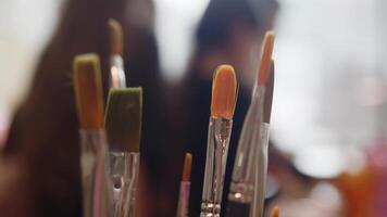 le nettoyer conseils de nombreuses hérissé brosses sont collage en dehors de une verre sur le artistes poste de travail. extrême fermer. lent mouvement. Contexte video