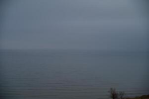 seascape with fog over the sea. sea horizon is visible, thick fog stands over the surface of the sea. land is not visible. photo