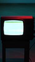 vertical Old analog television set displaying static noise in dark room video