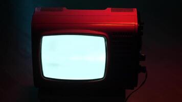 Old red television set displaying static screen in dark room video