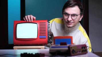 Portrait man with an old vintage analog TV. red television with blank screen and retro game console video