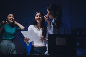 Three women standing in front of a computer photo