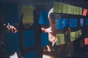 Business people looking at a window with sticky notes photo