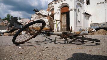 View to burned bike against the background of destroyed church at Kharkivska oblast. Ruined building after bomb attacks on ukrainian territory from russia army. russian invasion of Ukraine. Slow photo