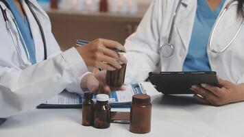 Two doctors are working on a tablet and bottles video