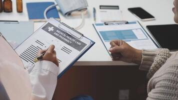 A doctor is holding a clipboard while another person is looking at it video