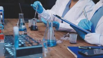Two people in lab coats working on a project video
