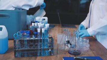 Two people in lab coats working on a table video