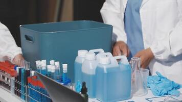 Two people in lab coats are working on a table video