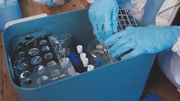 A person in a lab coat is holding a container with various items video