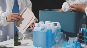 Two people in lab coats are working on a table video