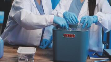 Two people in lab coats and gloves are working on a container video