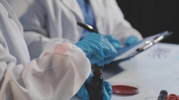 Two people in lab coats and gloves are working on a project video