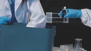 Two people in lab coats and gloves are working on a container video