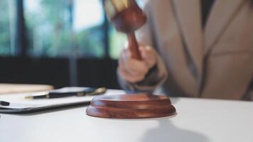 A judge's gavel is on a table in a courtroom video