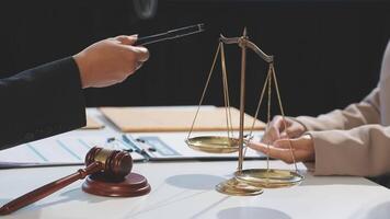 A judge is holding a scale with a pen and a woman's hand video