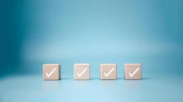 Checklist, Task list, Process success, Solving solution, Mission complete, Survey and assessment and voting, Quality Control, Goal achievement business, White correct check mark on wooden blocks. photo