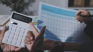 Business people using a calculator to calculate the cost of a project video