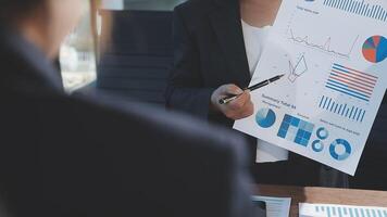 A businesswoman is holding a piece of paper with graphs and charts on it video