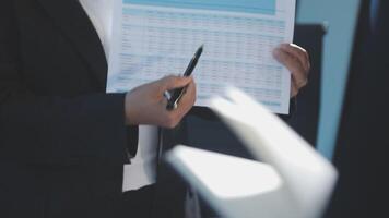 A man in a suit holding a piece of paper and pen video