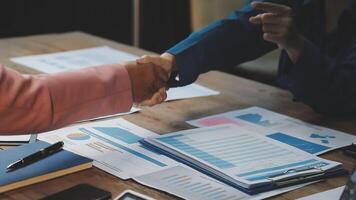 Two people shaking hands over papers on a table video