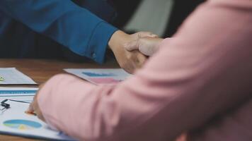Two people shaking hands over a table with papers video