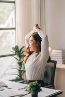 A woman is stretching her arms in front of a window photo