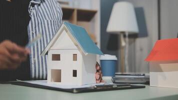 A man is holding a paper model of a house video