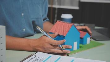 Man writing on paper with house model video