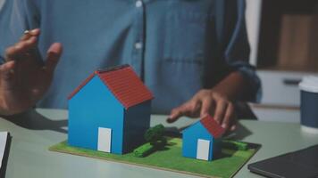 A person is holding a model of a house on a table video