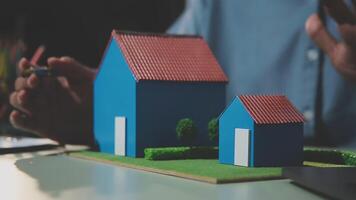 A person is working on a model of a house video