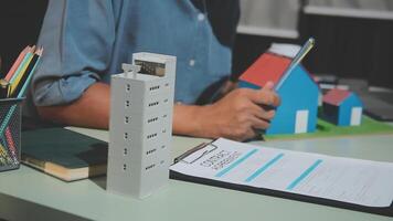 A man is working on a project with a model of a house on the table video