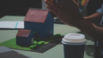 A man clapping his hands in front of a model of a house video