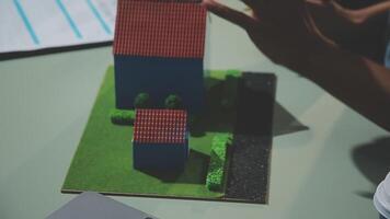 A person is holding a model of a house on a table video