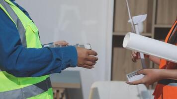 Two construction workers are holding a piece of paper video